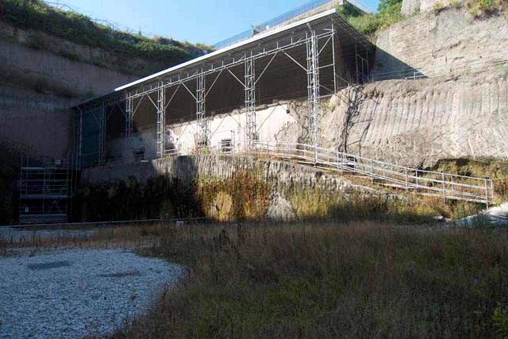 Villa dei Papiri, Herculaneum. July 2010. Ramp leading to lower and upper levels of the villa.
Photo courtesy of Michael Binns.
According to Guidobaldi and Esposito, there are at least two lower levels below the main atrium level.
The first lower level has a façade covered in smooth white plaster and is marked by large quadrangular windows.
Four of these windows also have splayed oculi above and there is a series of at least six rooms (I-VI) on this level.
See Esposito D. and Guidobaldi M., 2010. New Archaeological Research at the Villa of the Papyri, in the Villa of the Papyri at Herculaneum. Berlin: De Gruyter, pp. 33ff, fig. 23.